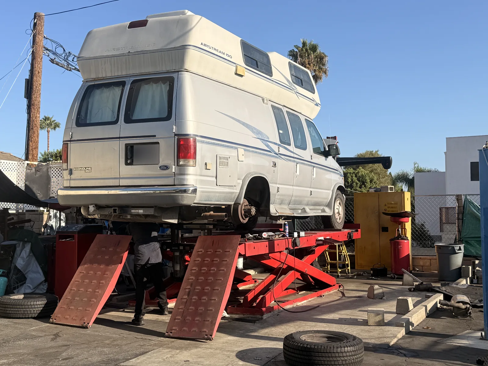 Camper van raised at Hillside with its rear wheel removed and a technician working underneath.